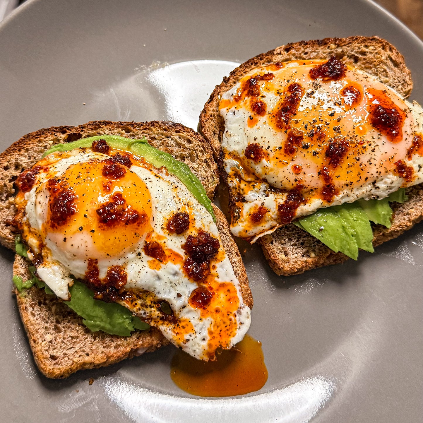 Fried eggs on avocado toast topped with El Pueblo Mexican chili oil